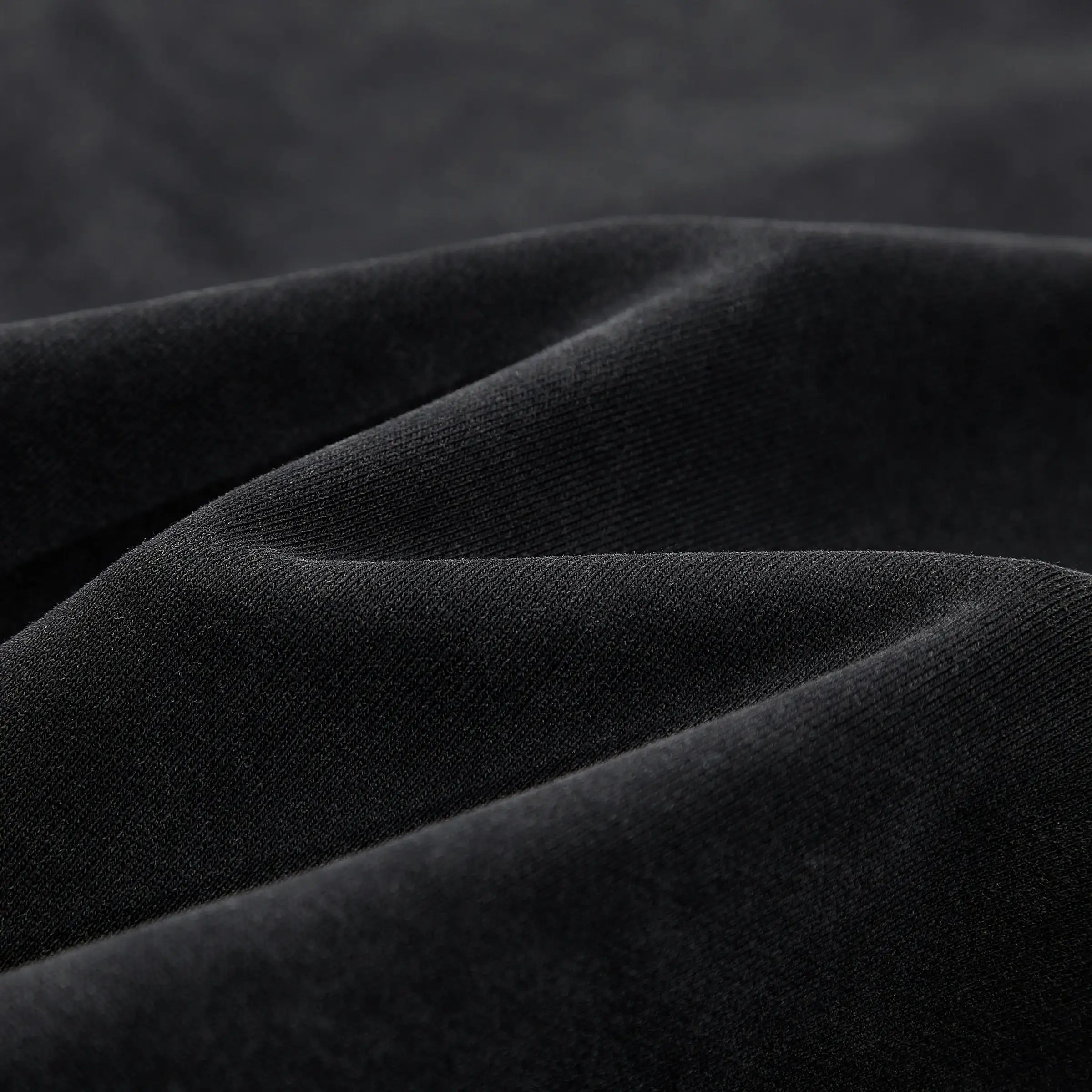 Close-up of black streetwear fabric with soft texture and subtle folds